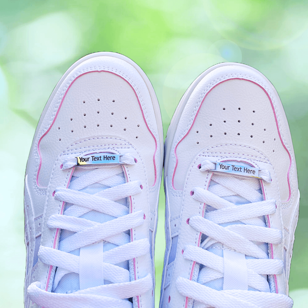 Image of etched shoe tags saying Your Text here on a pair of shoes on a blurry pale green background